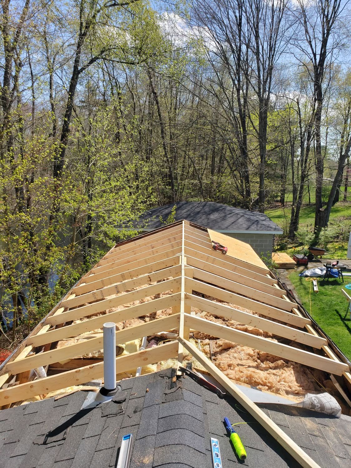 Roof framing construction with exposed wooden beams and insulation during installation on residential home